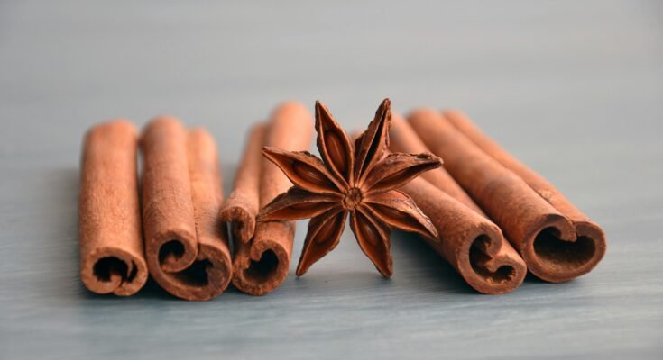 A collection of cinnamon sticks and ground cinnamon in a wooden bowl, highlighting the health benefits of cinnamon, such as antioxidant properties, blood sugar regulation, and heart health support.